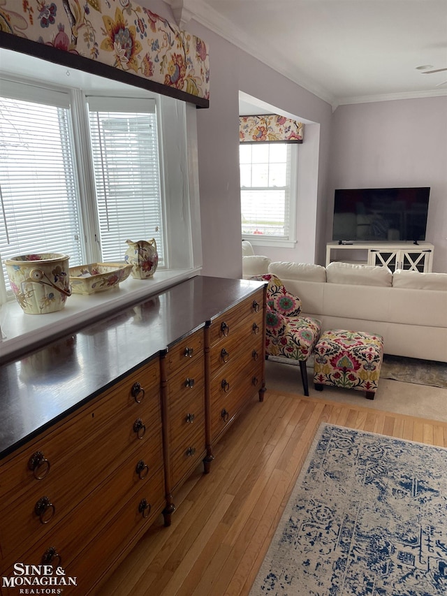 2740 River Rd, Marysville, MI 48040 - kitchen featuring brown cabinetry, stainless steel counters, ornamental molding, light wood-style floors, and open floor plan