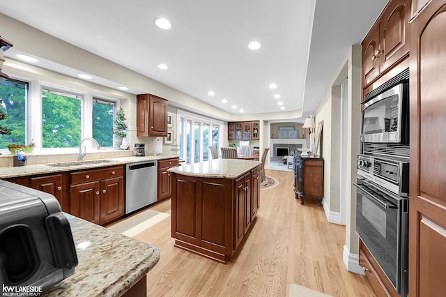 46713 Houghton Dr, Shelby Twp, MI 48315 - kitchen featuring appliances with stainless steel finishes, a sink, tasteful backsplash, light wood-style flooring, and a center island