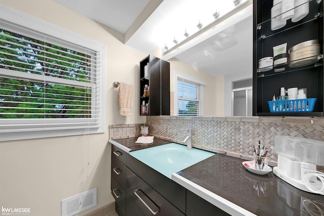 46713 Houghton Dr, Shelby Twp, MI 48315 - bathroom with backsplash, vanity, baseboards, and a shower with door