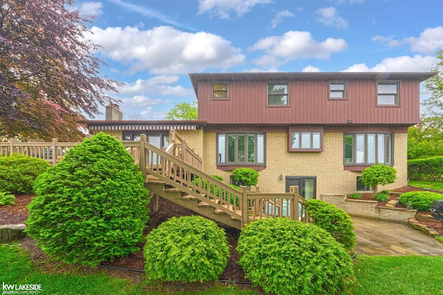 46713 Houghton Dr, Shelby Twp, MI 48315 - rear view of property featuring stairway, brick siding, a wooden deck, and a patio area