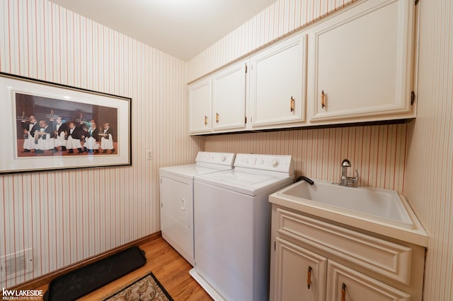 46713 Houghton Dr, Shelby Twp, MI 48315 - washroom with washer and dryer, wallpapered walls, cabinet space, and light wood-style flooring