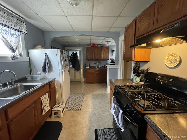 1110 N 2nd St, Ishpeming, MI 49849 - kitchen with black range with gas cooktop, under cabinet range hood, a sink, a drop ceiling, and arched walkways