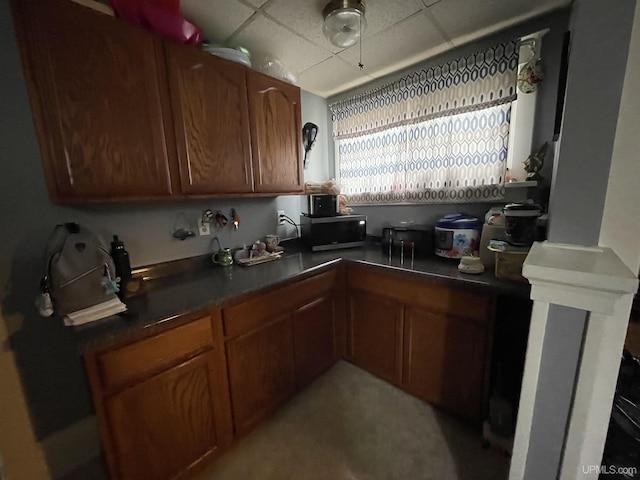 1110 N 2nd St, Ishpeming, MI 49849 - kitchen with dark countertops, a drop ceiling, and brown cabinets