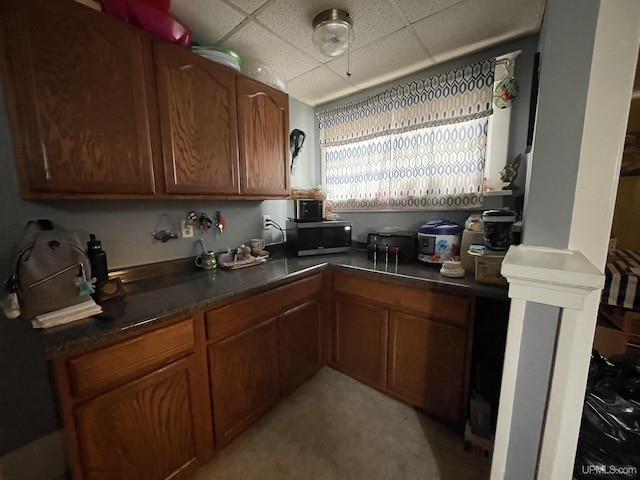 1110 N 2nd St, Ishpeming, MI 49849 - kitchen with a drop ceiling, stainless steel microwave, dark countertops, and brown cabinetry