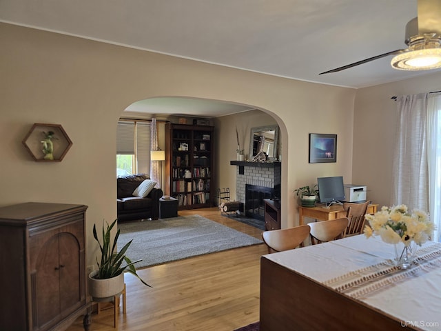 817 W Water St, Hancock, MI 49930 - living area featuring arched walkways, a brick fireplace, wood finished floors, and ceiling fan