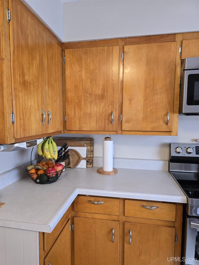 817 W Water St, Hancock, MI 49930 - kitchen featuring stainless steel appliances, light countertops, and brown cabinetry