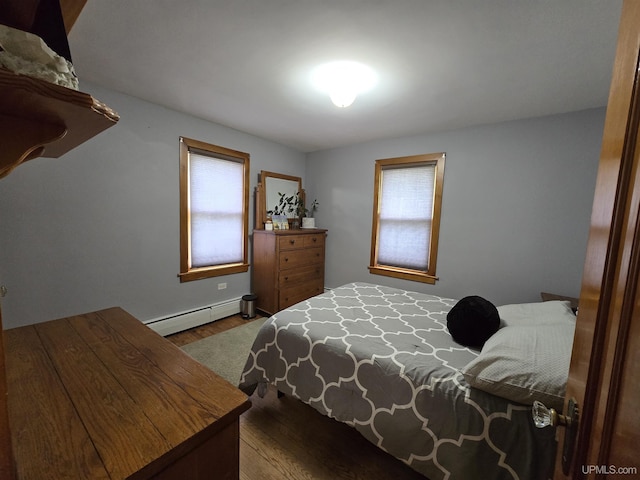 817 W Water St, Hancock, MI 49930 - bedroom featuring a baseboard heating unit and wood finished floors