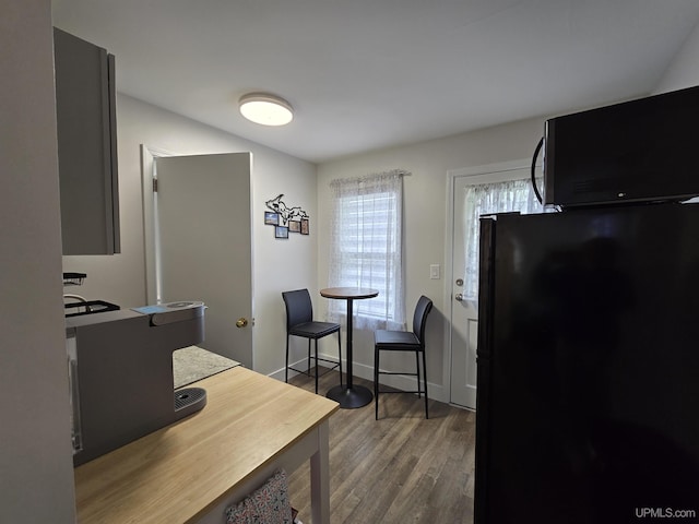 817 W Water St, Hancock, MI 49930 - kitchen with freestanding refrigerator, wood finished floors, and an office area