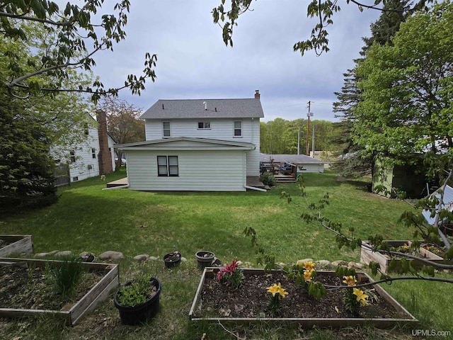 817 W Water St, Hancock, MI 49930 - back of property with a garden, a lawn, and a chimney