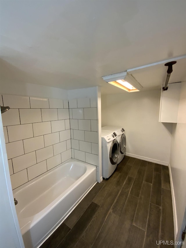 331 W Bluff St, Marquette, MI 49855 - bathroom featuring washing machine and clothes dryer, a tub to relax in, wood finished floors, baseboards, and a shower