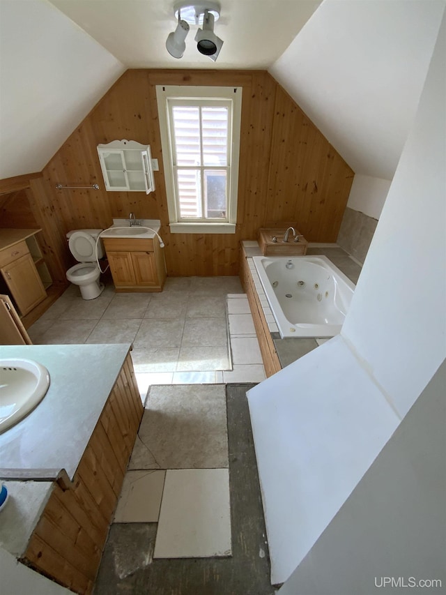 331 W Bluff St, Marquette, MI 49855 - full bathroom featuring wooden walls, vanity, a tub with jets, vaulted ceiling, and toilet