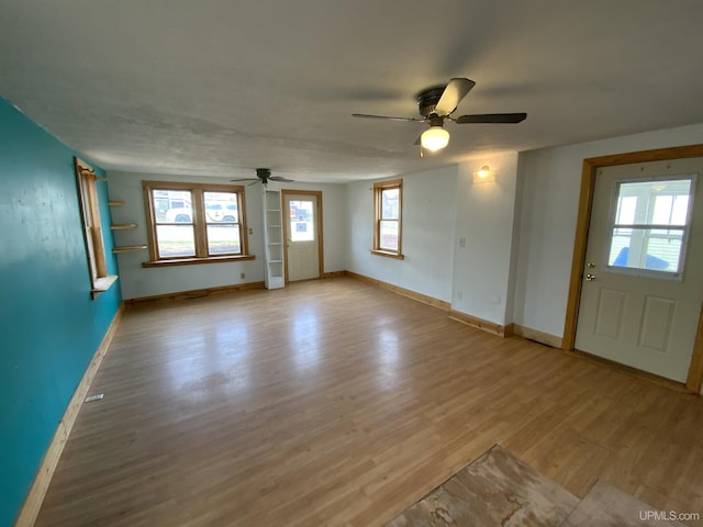 331 W Bluff St, Marquette, MI 49855 - unfurnished living room featuring a ceiling fan, light wood finished floors, baseboards, and plenty of natural light