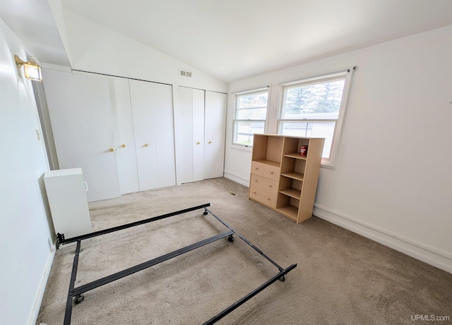 116 Caribou St, Gwinn, MI 49841 - unfurnished bedroom with multiple closets, carpet flooring, lofted ceiling, and baseboards
