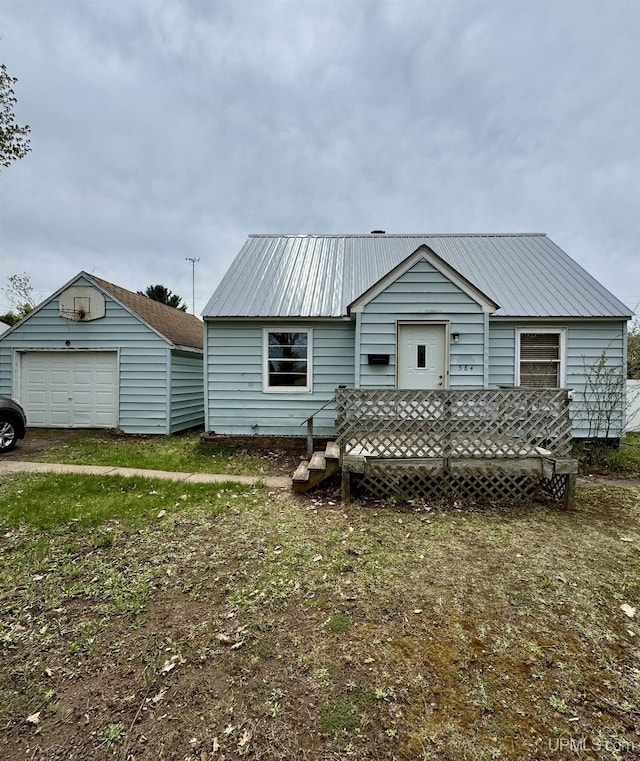584 Elliott Ave, Ishpeming, MI 49849 - view of front of home featuring metal roof, a detached garage, and an outbuilding