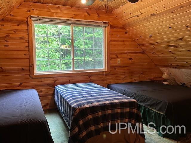 325 Mastodon Rd, Crystal Falls, MI 49920 - bedroom with wooden ceiling, wooden walls, lofted ceiling, and a ceiling fan