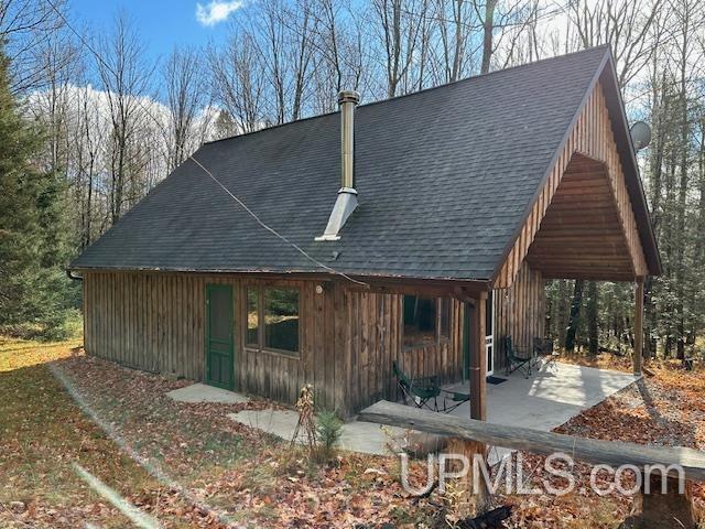 325 Mastodon Rd, Crystal Falls, MI 49920 - view of side of home featuring a patio and a shingled roof