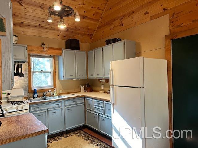 325 Mastodon Rd, Crystal Falls, MI 49920 - kitchen featuring white appliances, a sink, lofted ceiling, wooden ceiling, and light countertops