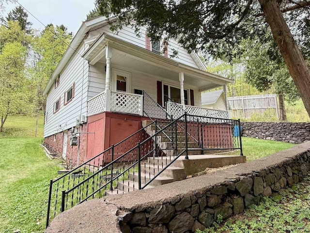 300 Jasper St, Ishpeming, MI 49849 - shotgun-style home with a front yard, stairs, and a porch