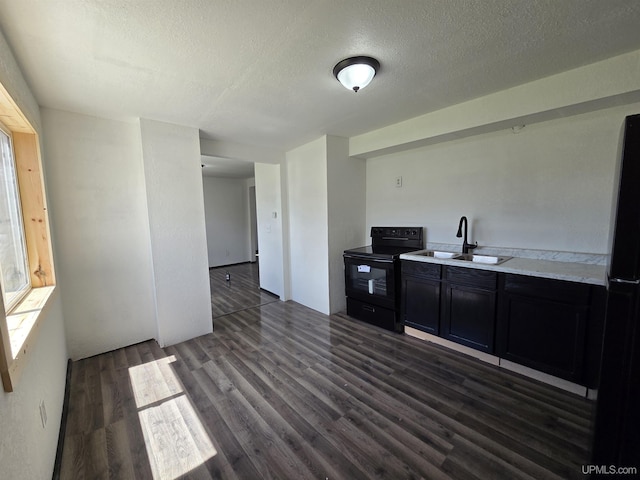 601 Range St, Manistique, MI 49854 - kitchen featuring black appliances, a sink, dark wood-type flooring, a textured ceiling, and light countertops