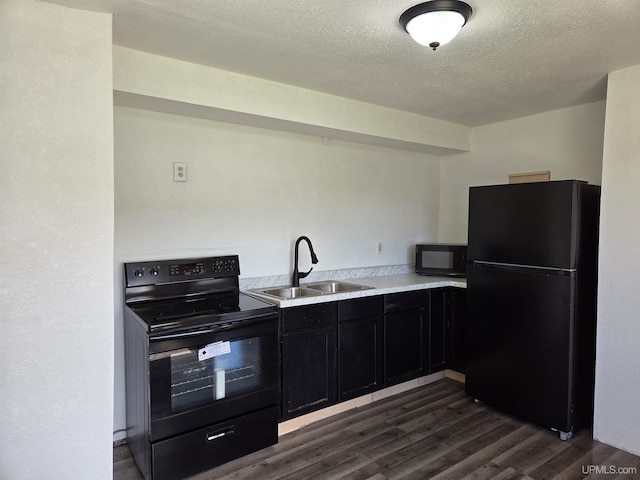 601 Range St, Manistique, MI 49854 - kitchen with black appliances, a sink, dark cabinetry, dark wood-type flooring, and a textured ceiling