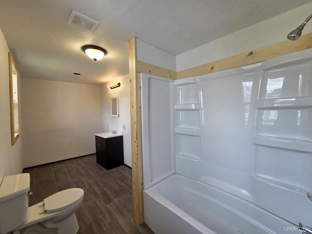 601 Range St, Manistique, MI 49854 - full bathroom featuring toilet, wood finished floors,  shower combination, vanity, and a textured ceiling