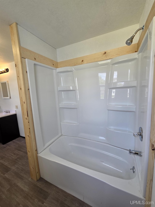 601 Range St, Manistique, MI 49854 - full bath featuring wood finished floors, vanity, and  shower combination