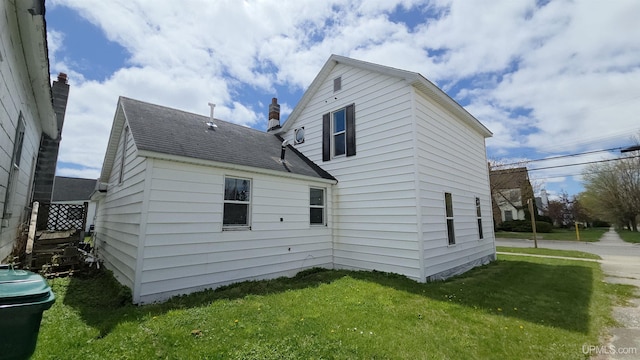 601 Range St, Manistique, MI 49854 - rear view of house with a lawn and roof with shingles
