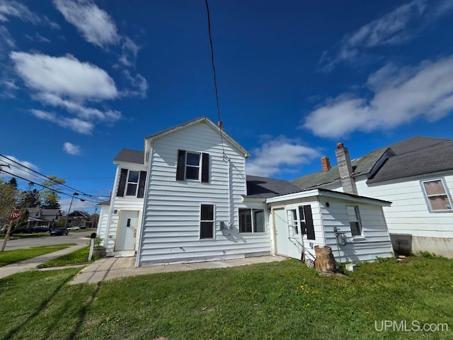 601 Range St, Manistique, MI 49854 - rear view of property with a yard and roof with shingles