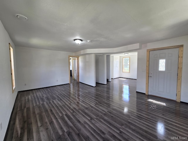 601 Range St, Manistique, MI 49854 - unfurnished living room featuring dark wood-style flooring and baseboards
