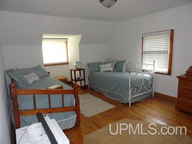 201 E Jewell St, Munising, MI 49862 - bedroom featuring wood finished floors and vaulted ceiling