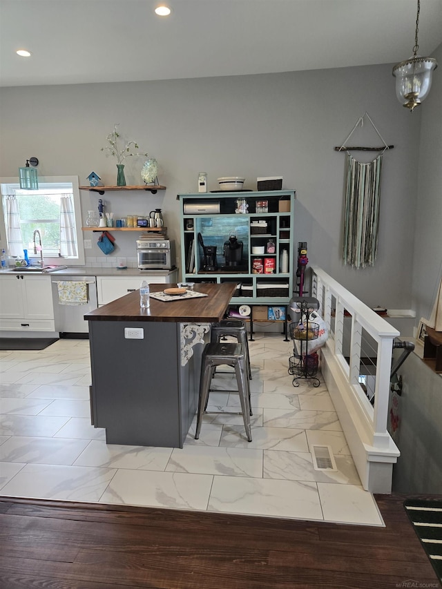 2450 N Lakeshore Rd, Carsonville, MI 48419 - kitchen with dishwasher, white cabinets, butcher block countertops, a kitchen island, and a sink