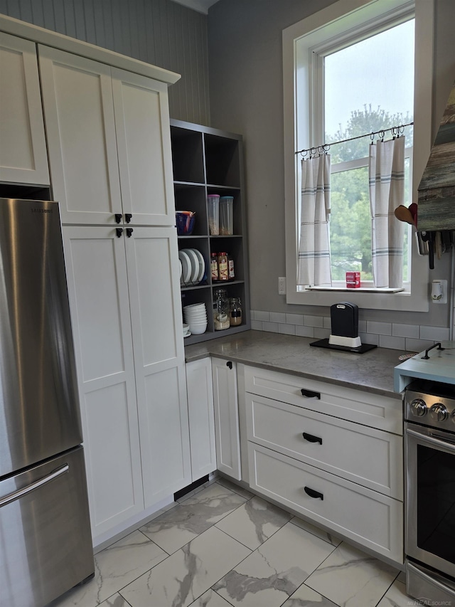 2450 N Lakeshore Rd, Carsonville, MI 48419 - kitchen with stainless steel appliances, light marble finish floors, and white cabinetry