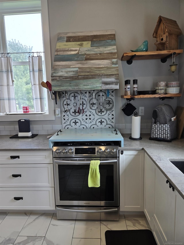 2450 N Lakeshore Rd, Carsonville, MI 48419 - kitchen with stainless steel electric range, white cabinetry, light marble finish flooring, and light stone counters