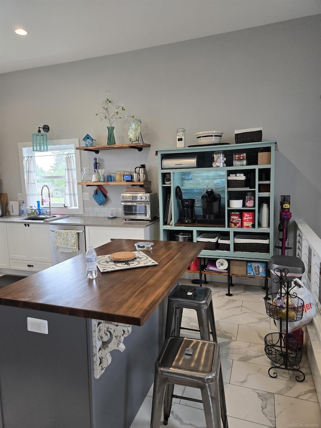 2450 N Lakeshore Rd, Carsonville, MI 48419 - kitchen with wooden counters, marble look tiles, white cabinetry, a sink, and dishwasher
