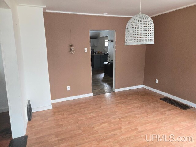 439 Hecla St, Lake Linden, MI 49945 - unfurnished dining area featuring crown molding, light wood-style flooring, and baseboards