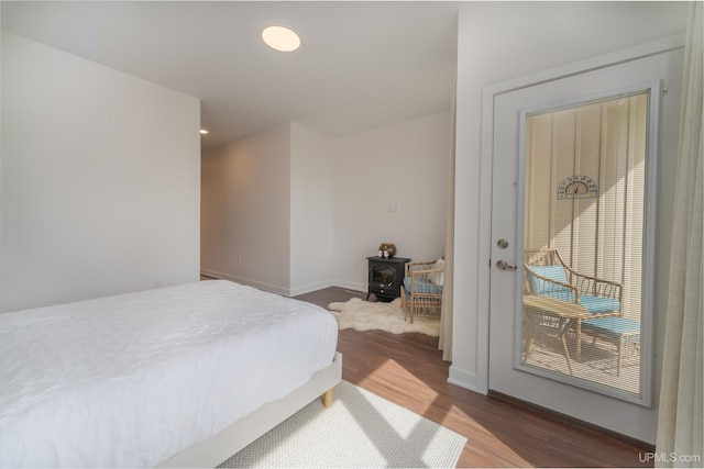 776 S Lakeshore Blvd, Marquette, MI 49855 - bedroom with dark wood-type flooring, a wood stove, and baseboards