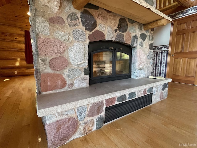 6856 Five Mile Point Rd, Allouez, MI 49805 - detailed view of a stone fireplace, wood finished floors, beamed ceiling, and log walls