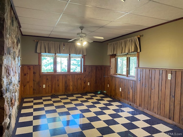 6856 Five Mile Point Rd, Allouez, MI 49805 - empty room with wainscoting, light floors, ceiling fan, a paneled ceiling, and ornamental molding