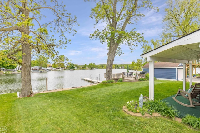 8878 Arlington Rd, White Lake, MI 48386 - view of green lawn featuring an outdoor structure, a deck with water view, and a dock