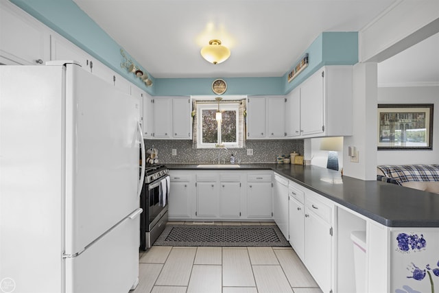 8878 Arlington Rd, White Lake, MI 48386 - kitchen featuring white appliances, dark countertops, a peninsula, backsplash, and a sink