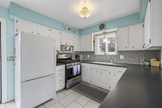 8878 Arlington Rd, White Lake, MI 48386 - kitchen with white appliances, a sink, dark countertops, and white cabinets