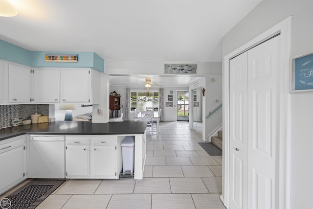 8878 Arlington Rd, White Lake, MI 48386 - kitchen featuring white dishwasher, dark countertops, white cabinetry, a peninsula, and tasteful backsplash