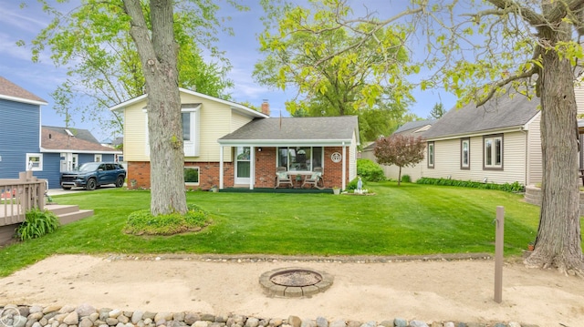 8878 Arlington Rd, White Lake, MI 48386 - view of front facade with a front yard, an outdoor fire pit, brick siding, a chimney, and a porch