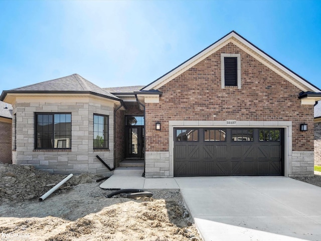55127 Saint Paul Dr, Macomb Twp, MI 48042 - french country inspired facade with stone siding, driveway, and brick siding