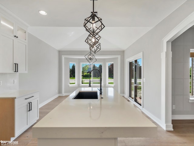 55127 Saint Paul Dr, Macomb Twp, MI 48042 - kitchen with a sink, decorative light fixtures, white cabinets, lofted ceiling, and baseboards