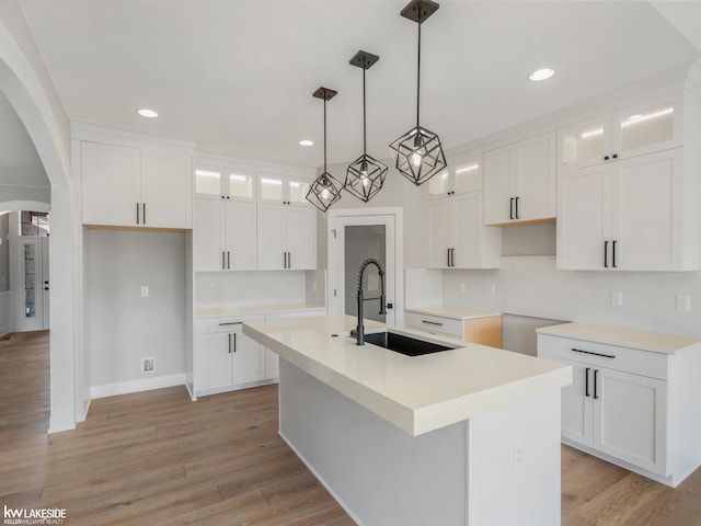 55127 Saint Paul Dr, Macomb Twp, MI 48042 - kitchen with a sink, a center island with sink, recessed lighting, arched walkways, and glass insert cabinets