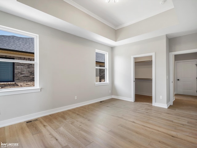 55127 Saint Paul Dr, Macomb Twp, MI 48042 - unfurnished bedroom featuring light wood finished floors, ornamental molding, baseboards, a spacious closet, and a closet