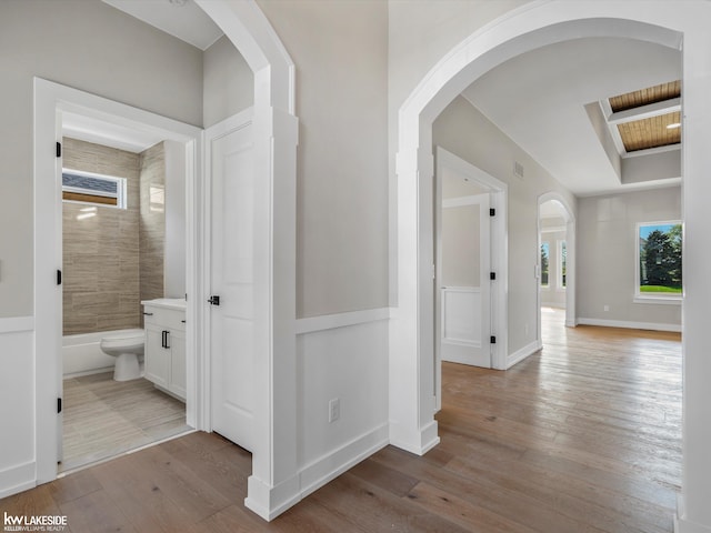 55127 Saint Paul Dr, Macomb Twp, MI 48042 - corridor featuring hardwood / wood-style floors, arched walkways, and a raised ceiling