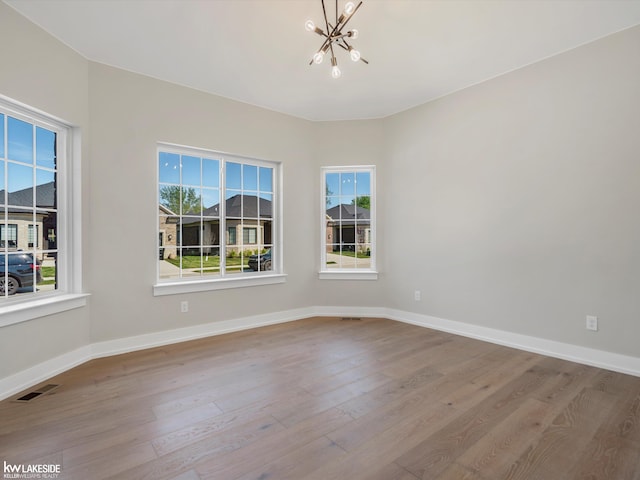 55127 Saint Paul Dr, Macomb Twp, MI 48042 - empty room with a chandelier, wood finished floors, and healthy amount of natural light