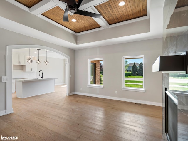 55127 Saint Paul Dr, Macomb Twp, MI 48042 - unfurnished living room with coffered ceiling, baseboards, a ceiling fan, light wood-style flooring, and wood ceiling with exposed beams